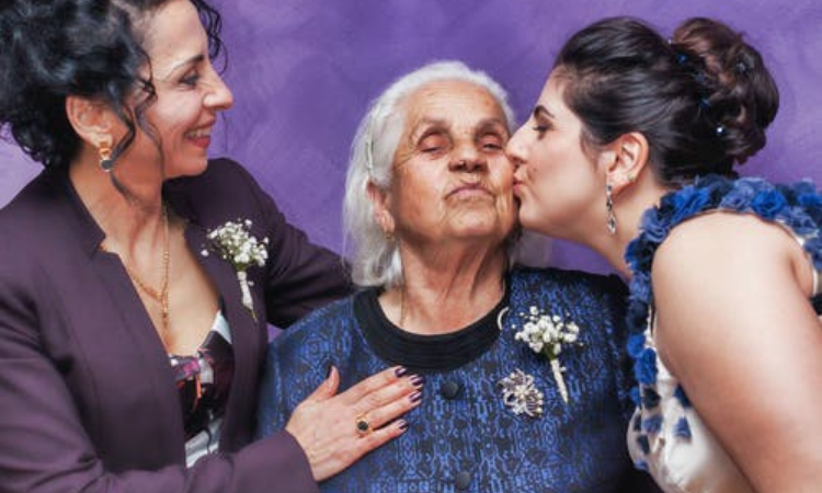 grandmother being kissed on the cheek by her family