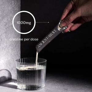 Hand pours Ancient + Brave True Creatine+ powder from a sachet into a glass of water; overlay notes 4100mg creatine per dose.

